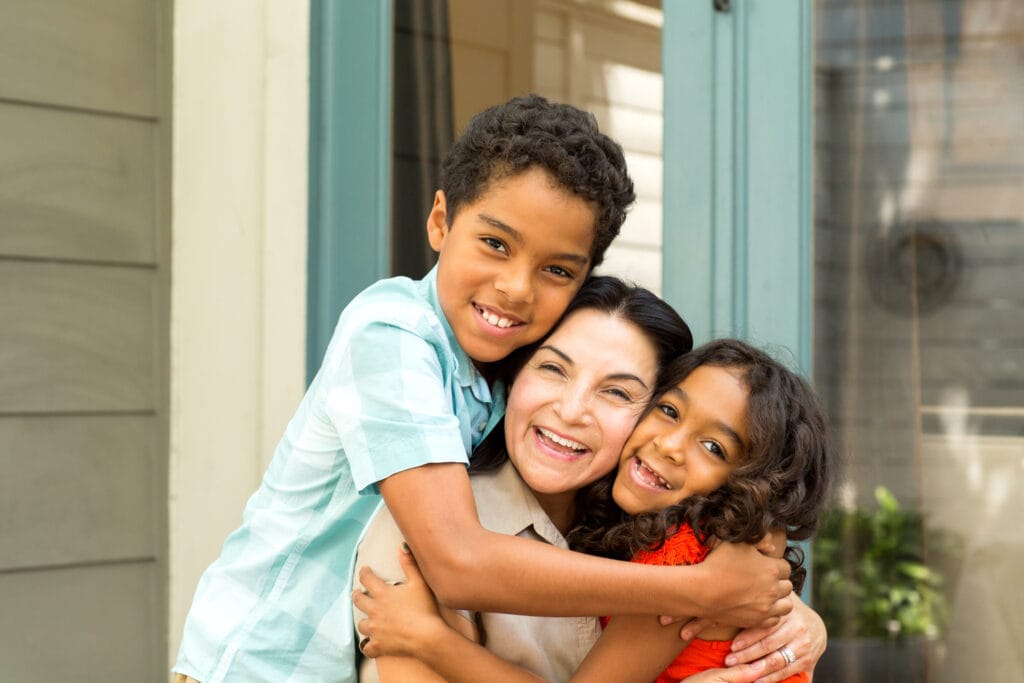 Hispnaic mother laughing and talking with her children.