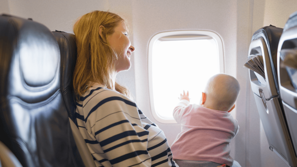 Mamá con bebé en avión, viajes de adopción, adopción, adopción nacional vs. adopción internacional, caminos hacia la adopción