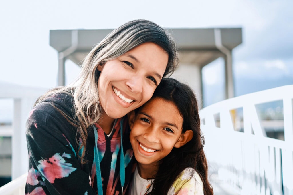 Happy Latin American mother and daughter hugging each other. Family love, people concept