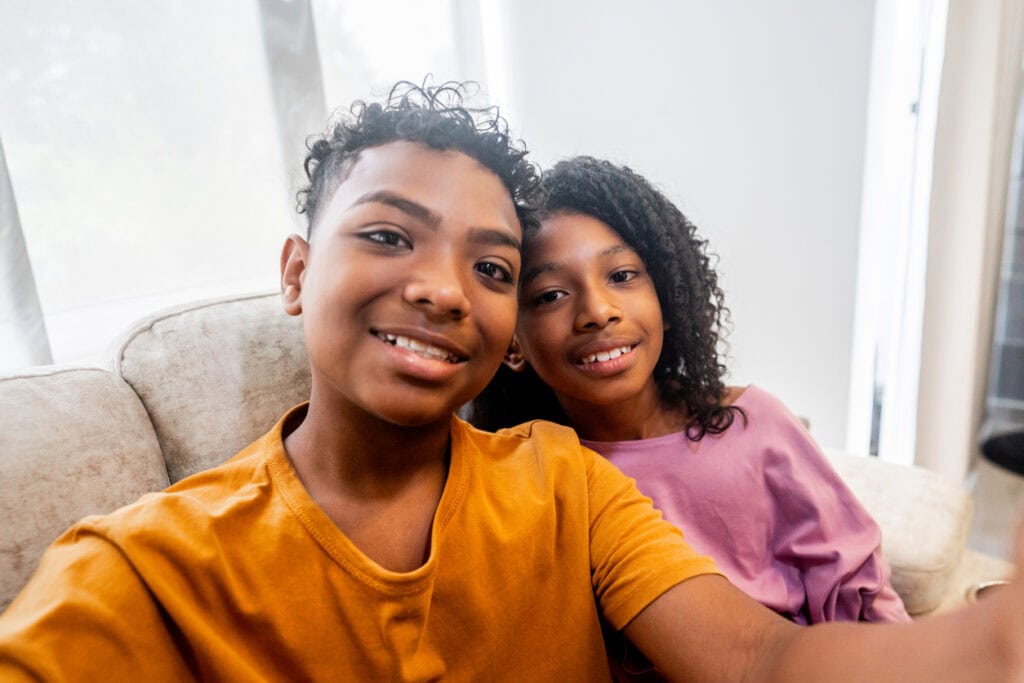 Siblings taking a selfie or filming at home camera point of view